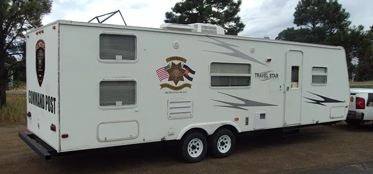 image of a large white trailer with several windows and a law enforcement logo