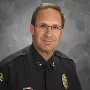 photo of john camper in a police uniform with a gray background